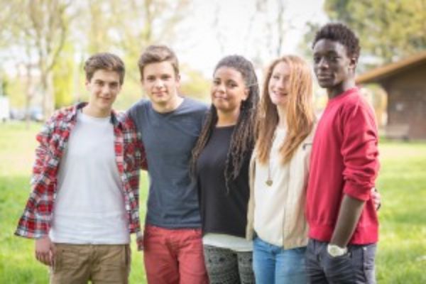 Groupe de pairs debout à l'extérieur dans une ligne, souriant