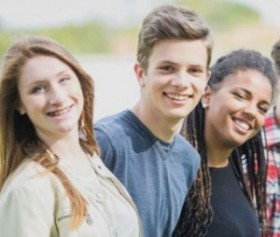 Peers standing outside in a line, smiling