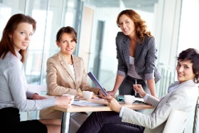 Employees gathered around a table, smiling