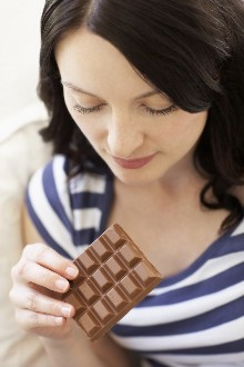 Woman looking at a chocolate bar in her hand