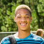 Boy in blue shirt smiling in the sun