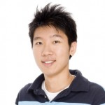 Boy in a navy blue polo smiling with a white background