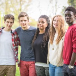 Group of teens standing in a line outside, smiling