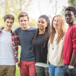 Groupe d'amis debout dehors sous un arbre