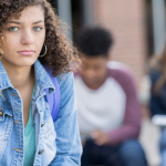 Adolescente devant deux pairs, à la triste